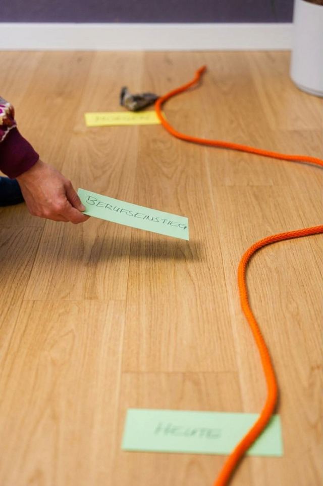 Eine Hand legt eine Karte auf den Boden