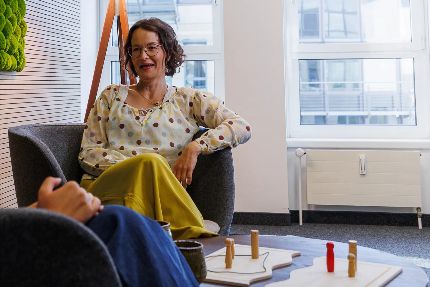 Julia Drowatzky im Beratungsraum, auf dem Tisch ein Systembrett